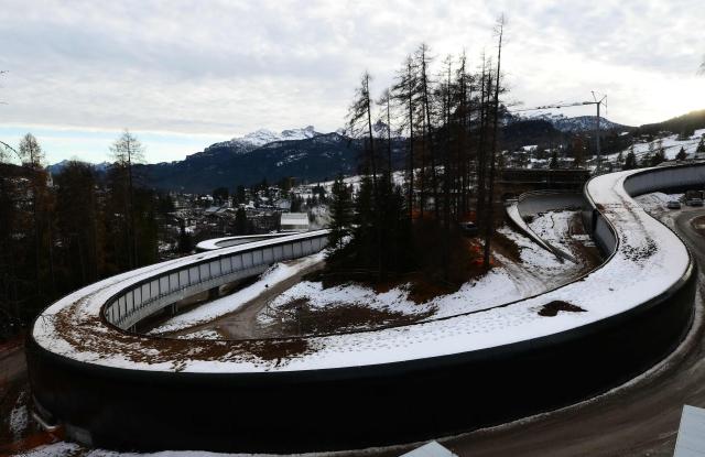 A picture shows the Cortina Sliding Centre, which will host bobsleigh, skeleton and luge competitions and Cortina d'Ampezzo valley in the background, ahead of the Milano Cortina 2026 Olympic Games, on December 11, 2025. (Photo by Stefano RELLANDINI / AFP)