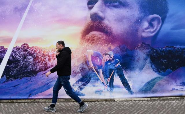 A man walks in Cortina d'Ampezzo downtown ahead of the Milano Cortina 2026 Olympic Games, on December 11, 2025. (Photo by Stefano RELLANDINI / AFP)