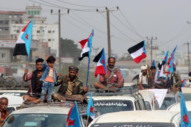 Yemenis members of the Sabahiha tribes of Lahj, who live along the strip between the south and north of the country, gather during a rally to show their support for the UAE-backed Southern Transitional Council (STC), which wants to revive an independent South Yemen, as they wave the old South Yemen flag in Khormaksar Square, in the coastal port city of Aden, the temporary capital of the Republic of Yemen on December 14, 2025. The STC is part of the internationally recognised government, which is a patchwork of groups held together by their opposition to Yemen's Houthi rebels. The Houthis hold most of the country's populated areas, including the capital Sanaa, in the north and west of the country. (Photo by Saleh Al-OBEIDI / AFP)