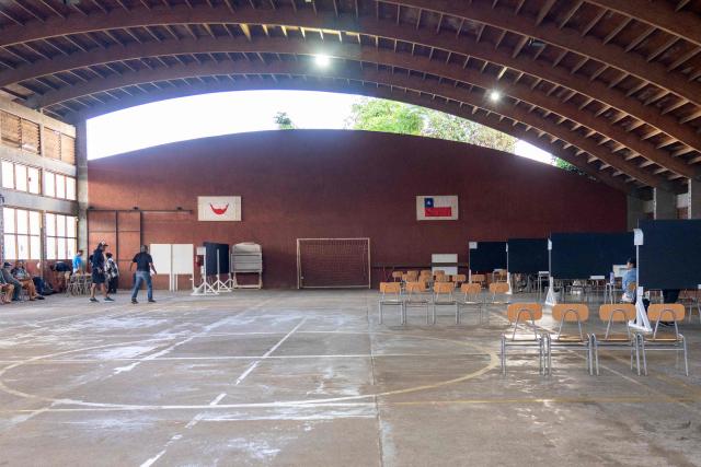 People wait to cast their vote during the presidential runoff election in Isla de Pascua (Easter Island), Chile, on December 14, 2025. Chileans head to the polls for a presidential runoff between Jeannette Jara, a communist backed by a broad left coalition, and Jose Antonio Kast, a devout far-right politico promising a hard line on security and migration. (Photo by Miguel CARRASCO / AFP)