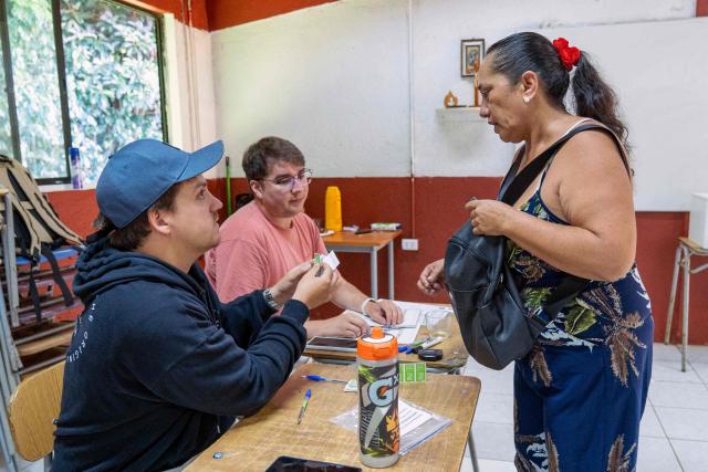 A woman prepares to cast her vote during the presidential runoff election in Isla de Pascua (Easter Island), Chile, on December 14, 2025. Chileans head to the polls for a presidential runoff between Jeannette Jara, a communist backed by a broad left coalition, and Jose Antonio Kast, a devout far-right politico promising a hard line on security and migration. (Photo by Miguel CARRASCO / AFP)