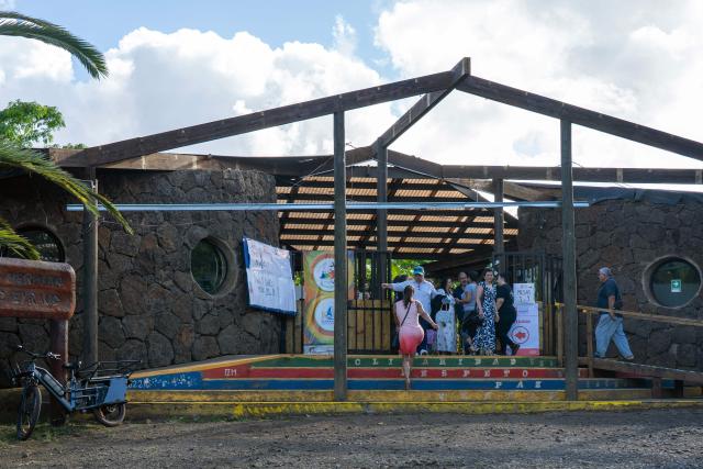 People enter a polling station to vote during the presidential runoff election in Isla de Pascua (Easter Island), Chile, on December 14, 2025. Chileans head to the polls for a presidential runoff between Jeannette Jara, a communist backed by a broad left coalition, and Jose Antonio Kast, a devout far-right politico promising a hard line on security and migration. (Photo by Miguel CARRASCO / AFP)