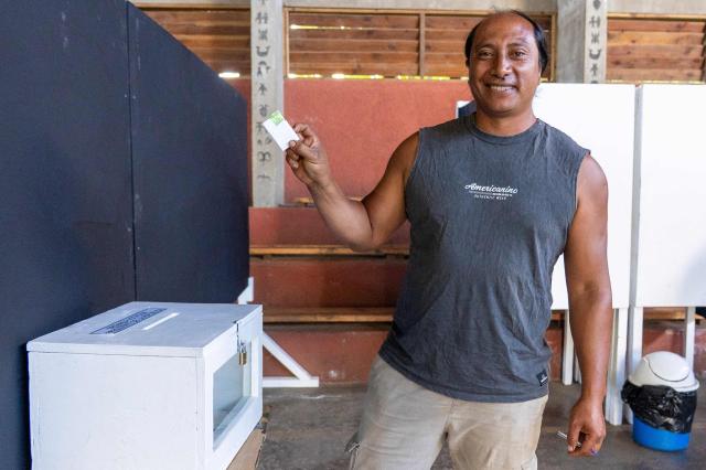 A man casts his vote during the presidential runoff election in Isla de Pascua (Easter Island), Chile, on December 14, 2025. Chileans head to the polls for a presidential runoff between Jeannette Jara, a communist backed by a broad left coalition, and Jose Antonio Kast, a devout far-right politico promising a hard line on security and migration. (Photo by Miguel CARRASCO / AFP)