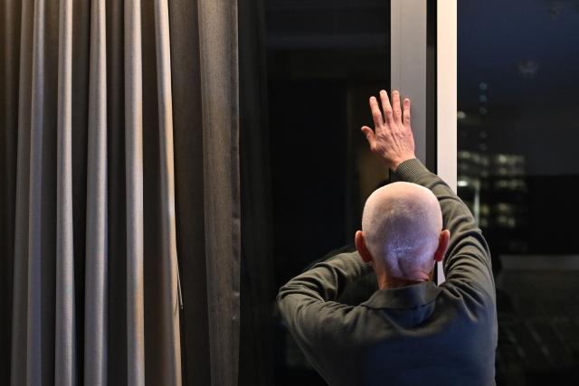 Nobel Peace Prize 2022 laureate Ales Bialiatski closes a window at his hotel room in Vilnius on December 14, 2025, a day after his release from prison. Belarus has freed 123 prisoners, including protest leaders Viktar Babaryka, Maria Kolesnikova, and Nobel Peace Prize laureate Ales Bialiatski, on December 13, 2025, after the US envoy earlier said Washington was lifting sanctions on Belarusian potassium. (Photo by Sergei GAPON / AFP)