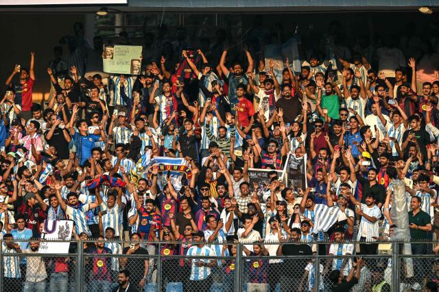 Fans of Argentina's footballer Lionel Messi cheer during his GOAT Tour at the Wankhede Stadium in Mumbai on December 14, 2025. (Photo by Indranil MUKHERJEE / AFP)