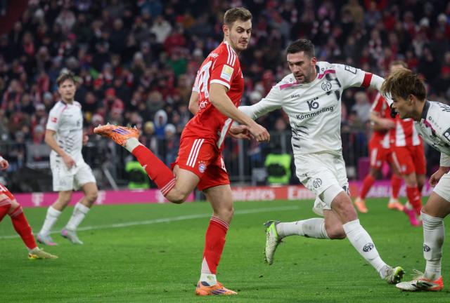 Bayern Munich's Croatian defender #44 Josip Stanisic and Mainz' German defender #16 Stefan Bell vie for the ball during the German first division Bundesliga football match between FC Bayern Munich and Mainz 05 in Munich, southern Germany on December 14, 2025. (Photo by Karl-Josef HILDENBRAND / AFP) / DFL REGULATIONS PROHIBIT ANY USE OF PHOTOGRAPHS AS IMAGE SEQUENCES AND/OR QUASI-VIDEO