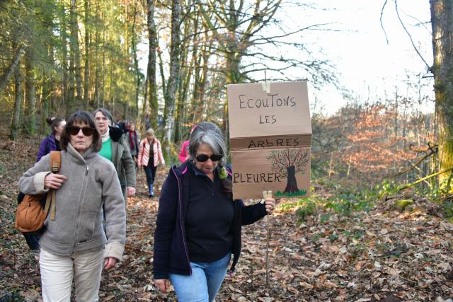 A protestor holds a sign reading "Listen to the trees crying" take part in a march organised by "collectif Alouettes 147" against the project of a new road (2x2 between Couzeix and Nieul), in Nieul, central France on December 14, 2025. (Photo by PASCAL LACHENAUD / AFP)