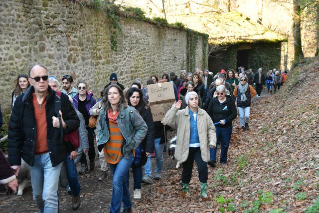 A protestor holds a sign reading "Listen to the trees crying" take part in a march organised by "collectif Alouettes 147" against the project of a new road (2x2 between Couzeix and Nieul), in Nieul, central France on December 14, 2025. (Photo by PASCAL LACHENAUD / AFP)