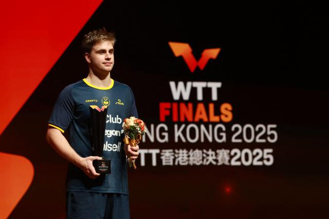 Sweden's Truls Moregard holds the runner-up's trophy following the men’s singles final match during the World Table Tennis (WTT) finals at the Hong Kong Coliseum in Hong Kong on December 14, 2025. (Photo by May JAMES / AFP)