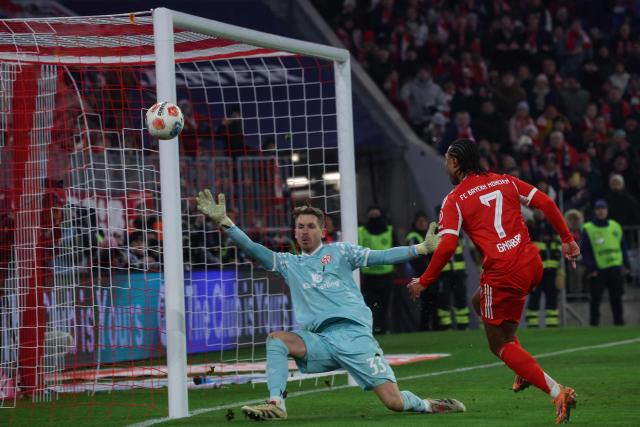 Bayern Munich's German forward #07 Serge Gnabry attempts to score past Mainz' German goalkeeper #33 Daniel Batz during the German first division Bundesliga football match between FC Bayern Munich and Mainz 05 in Munich, southern Germany on December 14, 2025. (Photo by Karl-Josef HILDENBRAND / AFP) / DFL REGULATIONS PROHIBIT ANY USE OF PHOTOGRAPHS AS IMAGE SEQUENCES AND/OR QUASI-VIDEO
