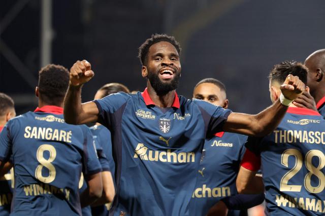Lens' French forward #11 Odsonne Edouard celebrates with teammates after scoring his team second goal during the French L1 football match between RC Lens and OGC Nice at the Stade Bollaert-Delelis in Lens, northern France, on December 14, 2025. (Photo by Francois LO PRESTI / AFP)