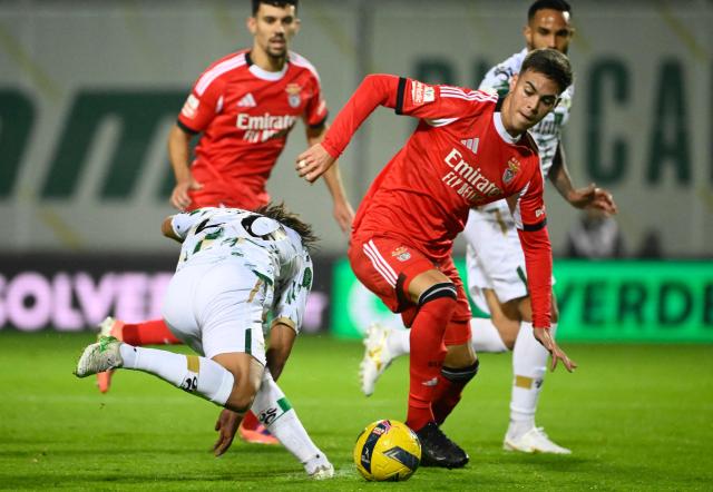 SL Benfica's Ukrainian midfielder #10 Georgiy Sudakov fights for the ball with Moreirense's Portuguese midfielder #20 Bernardo Martins during the Portuguese league football match between Moreirense FC and SL Benfica at the Comendador Joaquim de Almeida Freitas stadium in Moreira de Conegos on December 14, 2025. (Photo by Miguel RIOPA / AFP)