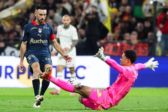 Lens' French midfielder #28 Adrien Thomasson tries to shoot in front of Nice's Senegalese goalkeeper #80 Yehvann Diouf (R) during the French L1 football match between RC Lens and OGC Nice at the Stade Bollaert-Delelis in Lens, northern France, on December 14, 2025. (Photo by Francois LO PRESTI / AFP)