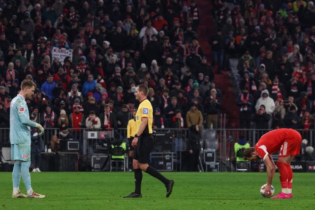 Bayern Munich's English forward #09 Harry Kane (R) preprase to take a penalty to socre the 2-2 goal past Mainz' German goalkeeper #33 Daniel Batz (L) during the German first division Bundesliga football match between FC Bayern Munich and Mainz 05 in Munich, southern Germany on December 14, 2025. (Photo by Karl-Josef HILDENBRAND / AFP) / DFL REGULATIONS PROHIBIT ANY USE OF PHOTOGRAPHS AS IMAGE SEQUENCES AND/OR QUASI-VIDEO