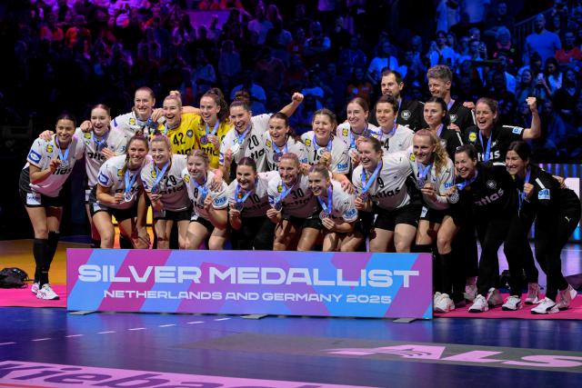 Germany's players pose holding their silver medals during the podium ceremony after winning 2nd place in the IHF Women's Handball World Championship at the Rotterdam Ahoy Arena, in Rotterdam on December 14, 2025. (Photo by JOHN THYS / AFP)