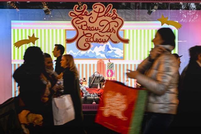 Pedestrians walk past the Galeries Lafayette a few days before Christmas in Paris on December 14, 2025. (Photo by Anna KURTH / AFP)