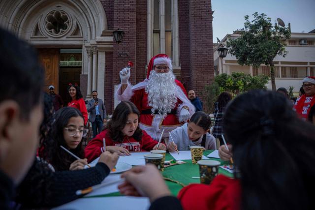 An Egyptian man dressed as Santa Clause rings a handbell outside the Saint Antoine Latin Catholic Church, during a celebration marking the start of Christmas festivities in downtown the capital Cairo on December 14, 2025. (Photo by Khaled DESOUKI / AFP)