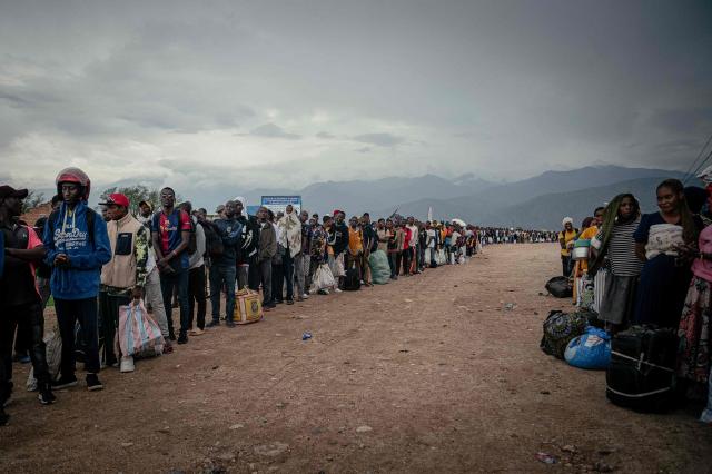 Displaced Burundian nationals line up with their belongings as they remain stranded on the Congolese side following the closure of the border between the Democratic Republic of Congo and Burundi at the Kavimvira border post on December 14, 2025. The M23 pressed onwards in the eastern Democratic Republic of Congo on December 13, 2025, even as Washington vowed action over its Rwandan backers' violation of a US-brokered peace deal.
The deal -- hailed by US President Donald Trump as a "miracle" -- was inked on December 4. Just says later, the Rwandan-backed M23 seized the key frontier city of Uvira along the border with Burundi, raising fears of the conflict breaking out into a regional war. (Photo by Jospin Mwisha / AFP)