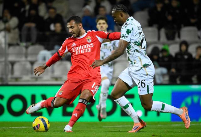 SL Benfica's Greek forward #14 Vangelis Pavlidis scores his team's second goal in spite of Moreirense's Brazilian defender #26 Maracas during the Portuguese league football match between Moreirense FC and SL Benfica at the Comendador Joaquim de Almeida Freitas stadium in Moreira de Conegos on December 14, 2025. (Photo by Miguel RIOPA / AFP)