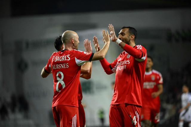 Benfica's Norwegian midfielder #08 Fredrik Aursnes (L) celebrates scoring his team's fourth goal with SL Benfica's Greek forward #14 Vangelis Pavlidis during the Portuguese league football match between Moreirense FC and SL Benfica at the Comendador Joaquim de Almeida Freitas stadium in Moreira de Conegos on December 14, 2025. (Photo by Miguel RIOPA / AFP)