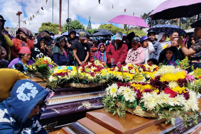 Indigenous mourn next to the coffins of victims of an armed confrontation in Nahuala, Solola department, Guatemala on December 14, 2025. The Guatemalan government restricted certain civil rights for 15 days in the indigenous region where at least five people were shot dead on December 13, 2025, President Bernardo Arevalo announced a day after. Solola, west of Guatemala City, has been the scene of clashes for years over a land dispute between the indigenous communities of Santa Catarina Ixtahuacan and Nahuala. (Photo by AFP stringer / AFP)