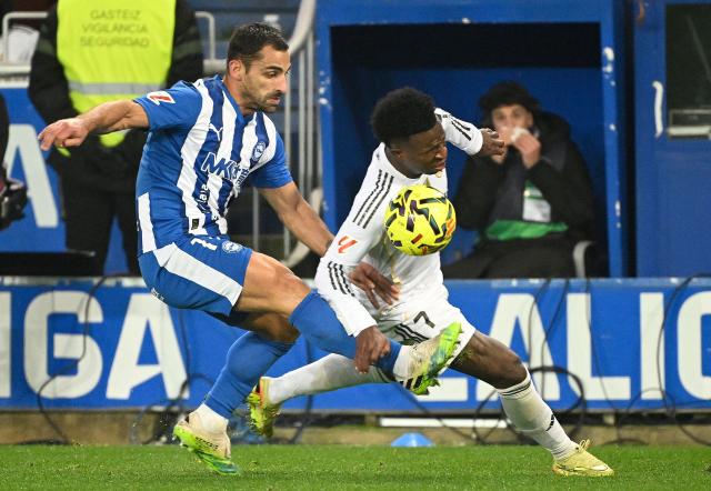Alaves' Spanish defender #17 Jonny Castro fights for the ball with Real Madrid's Brazilian forward #07 Vinicius Junior during the Spanish league football match between Deportivo Alaves and Real Madrid CF at the Mendizorroza stadium in Vitoria on December 14, 2025. (Photo by ANDER GILLENEA / AFP)