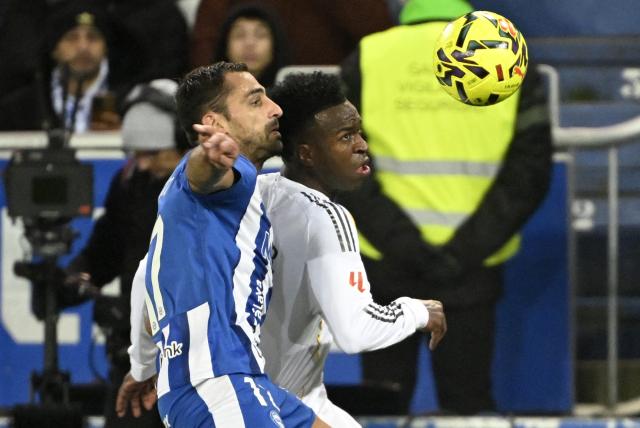 Alaves' Spanish defender #17 Jonny Castro fights for the ball with Real Madrid's Brazilian forward #07 Vinicius Junior during the Spanish league football match between Deportivo Alaves and Real Madrid CF at the Mendizorroza stadium in Vitoria on December 14, 2025. (Photo by ANDER GILLENEA / AFP)