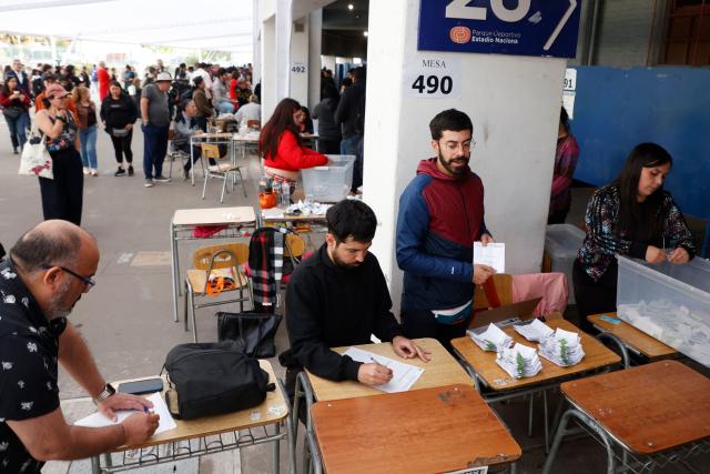 Election officials count votes after polls close during the presidential runoff election in Santiago on December 14, 2025. Chileans head to the polls for a presidential runoff between Jeannette Jara, a communist backed by a broad left coalition, and Jose Antonio Kast, a devout far-right politico promising a hard line on security and migration. (Photo by Raul BRAVO / AFP)