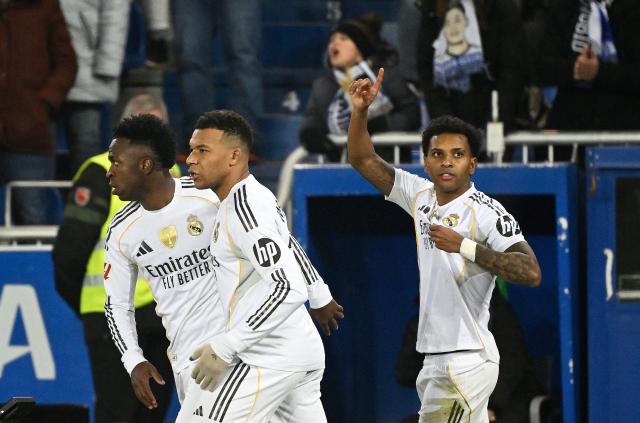TOPSHOT - Real Madrid's Brazilian forward #11 Rodrygo (R) celebrates scoring his team's second goal with Real Madrid's Brazilian forward #07 Vinicius Junior and Real Madrid's French forward #10 Kylian Mbappe during the Spanish league football match between Deportivo Alaves and Real Madrid CF at the Mendizorroza stadium in Vitoria on December 14, 2025. (Photo by ANDER GILLENEA / AFP)