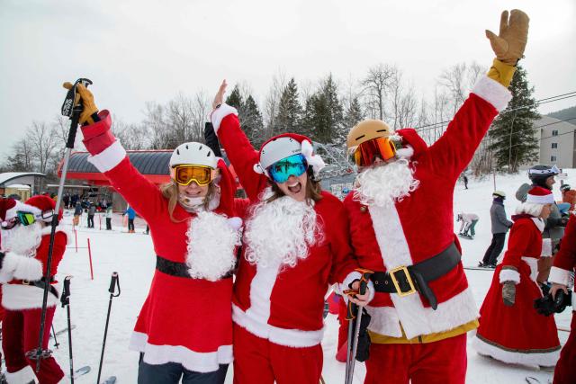 People cheer dressed as Santa at South Ridge at Sunday River resort in Newry Maine, on Sunday, December 14, 2025, to raise money for The River Fund and the Boyne Forever Foundation. (Photo by LAUREN OWENS LAMBERT / AFP)