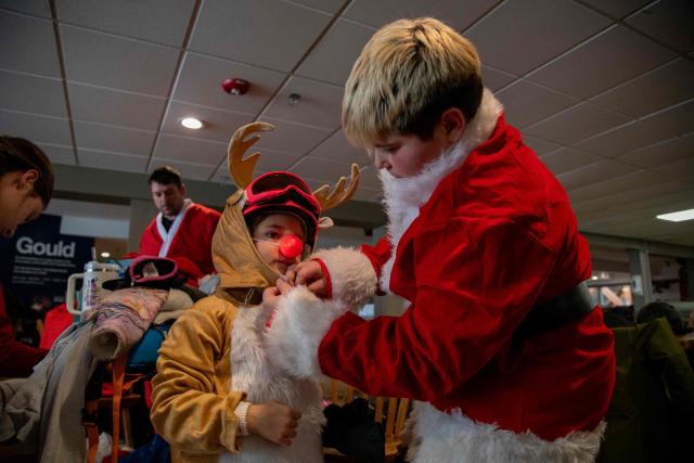 People boot up and get their Santa outfits on at Sunday River resort in Newry Maine, on Sunday, December 14, 2025, to raise money for The River Fund and the Boyne Forever Foundation. (Photo by LAUREN OWENS LAMBERT / AFP)