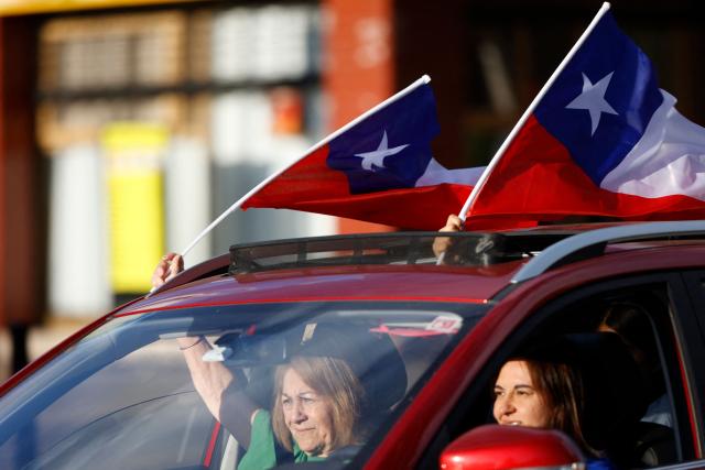 Supporters of Chile's presidential candidate Jose Antonio Kast, of the Partido Republicano party, celebrate following the first results of the presidential runoff election in Santiago on December 14, 2025. (Photo by Raul BRAVO / AFP)
