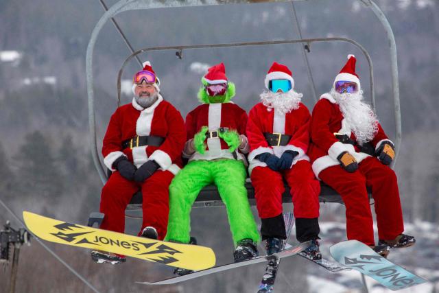 People dressed in Santa Claus costumes ride up the chairlift at South Ridge at Sunday River resort in Newry Maine, on Sunday, December 14, 2025, to raise money for The River Fund and the Boyne Forever Foundation. (Photo by Lauren OWENS LAMBERT / AFP)