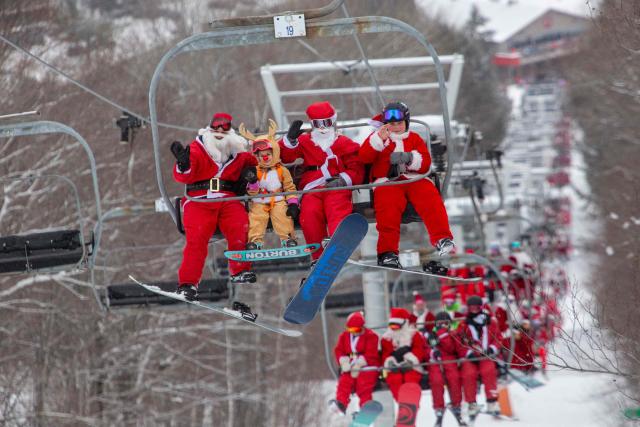 People dressed in Santa Claus costumes ride up the chairlift at South Ridge at Sunday River resort in Newry Maine, on Sunday, December 14, 2025, to raise money for The River Fund and the Boyne Forever Foundation. (Photo by Lauren OWENS LAMBERT / AFP)