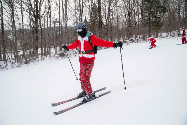 People dressed in Santa Claus costumes ski down South Ridge at Sunday River resort in Newry Maine, on Sunday, December 14, 2025, to raise money for The River Fund and the Boyne Forever Foundation. (Photo by LAUREN OWENS LAMBERT / AFP)