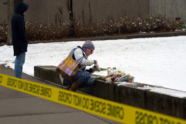 People mourn near a makeshift memorial outside the Barus & Holley engineering building on the campus of Brown University, in Providence, Rhode Island on December 14, 2025. US authorities on Sunday detained a person of interest in the mass shooting at Brown University that left two people dead and nine others wounded, the latest in a long line of school attacks nationwide. (Photo by Bing Guan / AFP)
