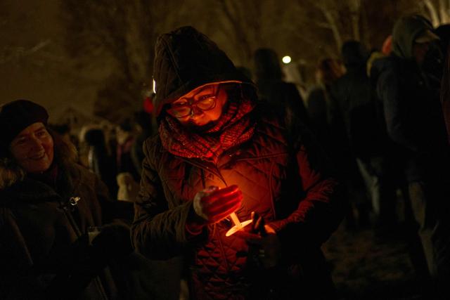 People participate in a candlelight vigil the following day of a mass shooting on the campus of Brown University, in Providence, Rhode Island on December 14, 2025. US authorities on Sunday detained a person of interest in the mass shooting at Brown University that left two people dead and nine others wounded, the latest in a long line of school attacks nationwide. (Photo by Bing Guan / AFP)