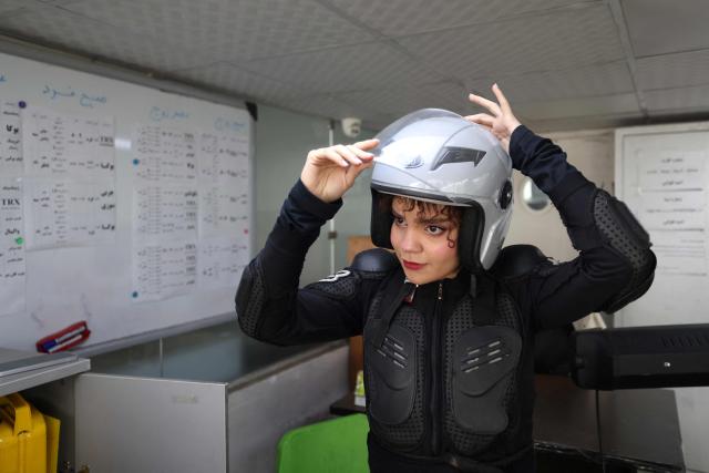 Iranian female students Narghe dons her helmet, as she gets ready for a motorbike riding lesson at a training center, in northern Tehran on December 7, 2025. Despite the progress, motorbike and scooter licensing for women remains a major hurdle in Iran and a legally grey area.
While traffic laws do not explicitly ban women from riding, authorities have never issued motorcycle licences to them in practice, with the issue gaining urgency with the noticeable rise in women riding. (Photo by ATTA KENARE / AFP)