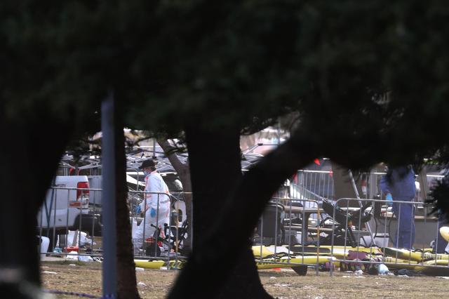 Forensic experts inspect the scene of a shooting at Bondi Beach in Sydney on December 15, 2025. A father-and-son team toting long-barrelled guns shot and killed 15 people including a 10-year-old girl at Sydney's Bondi Beach, authorities said on December 15, labelling it an antisemitic terrorist attack on a Jewish festival. (Photo by DAVID GRAY / AFP)