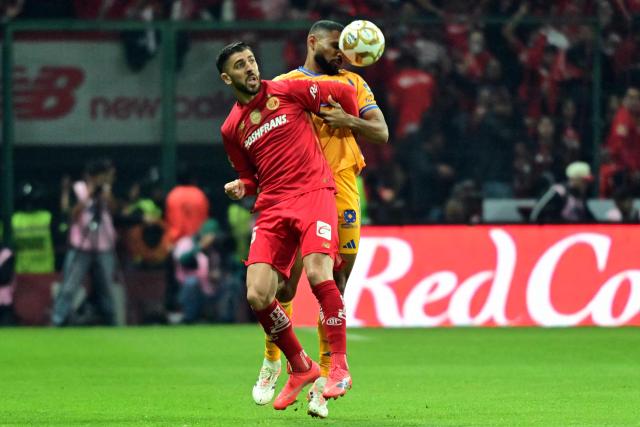 Toluca's Portuguese forward #26 Paulinho and Tigres' defender #04 Juan Jose Purata fight for the ball during the Liga MX Apertura final second leg football match between Toluca and Tigres at the Nemesio Diez stadium in Toluca, Mexico on December 14, 2025. (Photo by Mario Vazquez / AFP)