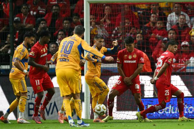 Tigres' French forward #10 Andre-Pierre Gignac shoots the ball and teammate Uruguayan midfielder #08 Fernando Gorriaran scores his team's first goal during the Liga MX Apertura final second leg football match between Toluca and Tigres at the Nemesio Diez stadium in Toluca, Mexico on December 14, 2025. (Photo by Yuri CORTEZ / AFP)
