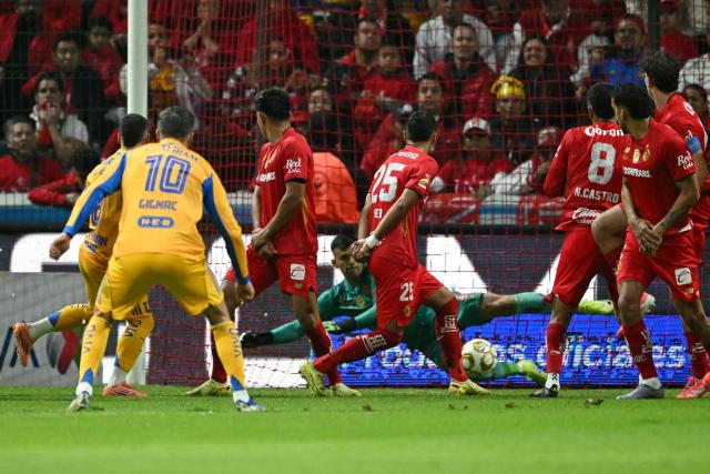 Tigres' French forward #10 Andre-Pierre Gignac shoots the ball and teammate Uruguayan midfielder #08 Fernando Gorriaran scores his team's first goal during the Liga MX Apertura final second leg football match between Toluca and Tigres at the Nemesio Diez stadium in Toluca, Mexico on December 14, 2025. (Photo by Yuri CORTEZ / AFP)