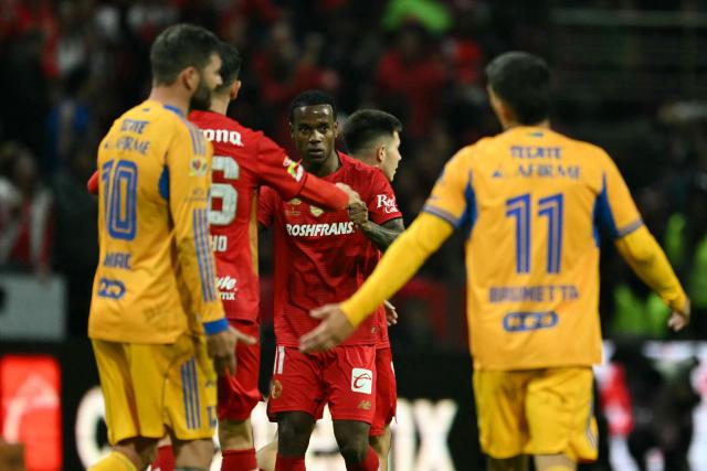 Toluca's Brazilian midfielder #11 Helinho (C) celebrates with teammate Portuguese forward #26 Paulinho after scoring his team's first goal during the Liga MX Apertura final second leg football match between Toluca and Tigres at the Nemesio Diez stadium in Toluca, Mexico on December 14, 2025. (Photo by Yuri CORTEZ / AFP)