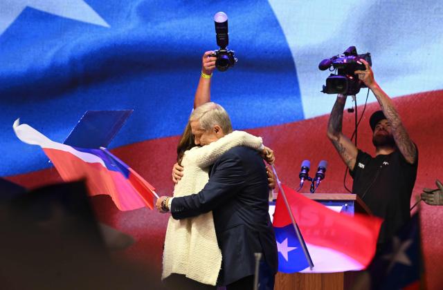 Chile's presidential candidate Jose Antonio Kast (R), of the Partido Republicano party, and his wife Maria Pia Adriasola (L) hug as they celebrate the results of the presidential runoff election in Santiago on December 14, 2025. Chilean voters elected Jose Antonio Kast, the most right-wing president in 35 years of democracy, with a thumping 58 percent of votes and his rival Jeannette Jara conceding defeat, according to official results on December 14, 2025. (Photo by Eitan ABRAMOVICH / AFP)