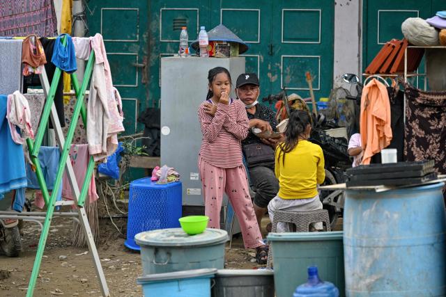 People rest after cleaning their house at a flood-affected area in Meureudu, in Indonesia's Aceh province on December 14, 2025. Devastating floods and landslides have killed 1,006 people in Indonesia, rescuers said December 13 as the Southeast Asian nation grapples with the huge scale of relief efforts. (Photo by CHAIDEER MAHYUDDIN / AFP)