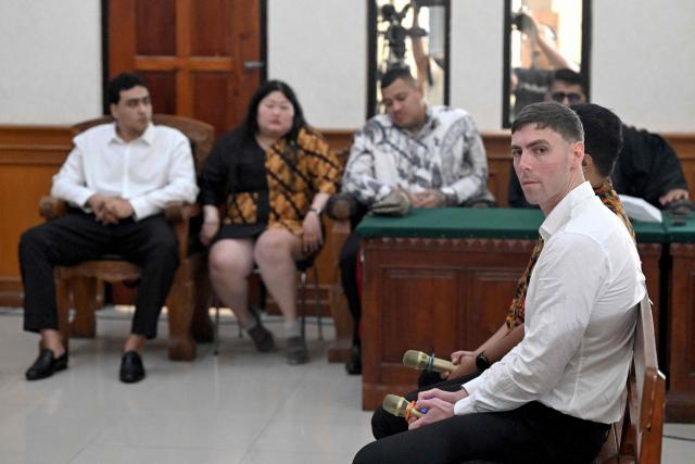 Australian suspect Darcy Francesco Jenson (R) attends a hearing as part of a trial at a courtroom in Denpasar on Indonesia's resort island of Bali on December 15, 2025. The trial of three Australians accused of plotting the murder of a compatriot at a villa in Bali continues, with all facing the death penalty. (Photo by SONNY TUMBELAKA / AFP)
