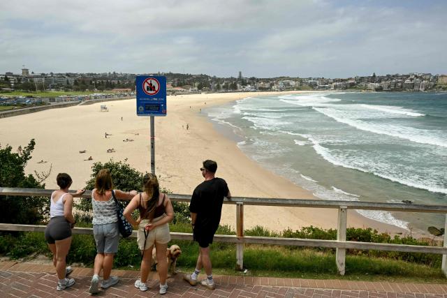 People are seen at Bondi Beach in Sydney on December 15, 2025, a day after the shootings. A father-and-son team toting long-barrelled guns shot and killed 15 people including a 10-year-old girl at Sydney's Bondi Beach on December 14, with authorities labelling it an antisemitic terrorist attack on a Jewish festival. (Photo by Saeed KHAN / AFP)