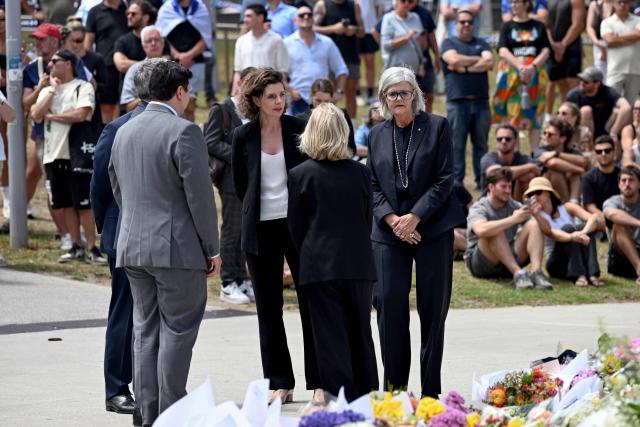 Australia's Governor-General Sam Mostyn (R) and local MP Allegra Spender (C) speak to locals at the Bondi Pavillion in the aftermath of the Bondi Beach shootings in Sydney on December 15, 2025. A father-and-son team toting long-barrelled guns shot and killed 15 people including a 10-year-old girl at Sydney's Bondi Beach on December 14, with authorities labelling it an antisemitic terrorist attack on a Jewish festival. (Photo by Saeed KHAN / AFP)