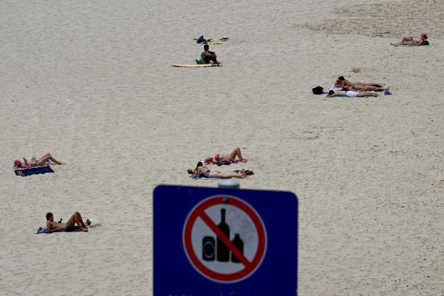People are seen at Bondi Beach in Sydney on December 15, 2025, a day after the shootings. A father-and-son team toting long-barrelled guns shot and killed 15 people including a 10-year-old girl at Sydney's Bondi Beach on December 14, with authorities labelling it an antisemitic terrorist attack on a Jewish festival. (Photo by Saeed KHAN / AFP)
