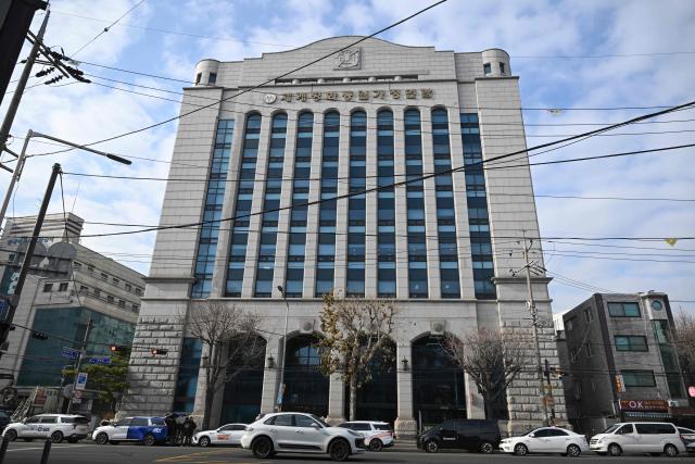 The emblem of Unification Church with Korean words reading "Family Federation for World Peace and Unification" is seen on the exterior of the church's headquarters in Seoul on December 15, 2025. South Korean police raided the headquarters of the cult-like Unification church on December 15, and named its leader as a suspect in the bribery of several high-profile politicians. (Photo by Jung Yeon-je / AFP)